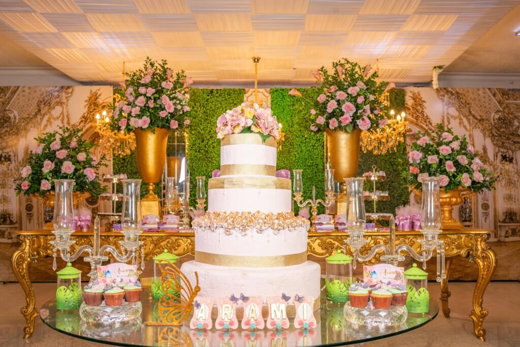 Elegant quinceañera celebration setup with floral decoration and a grand cake centerpiece.