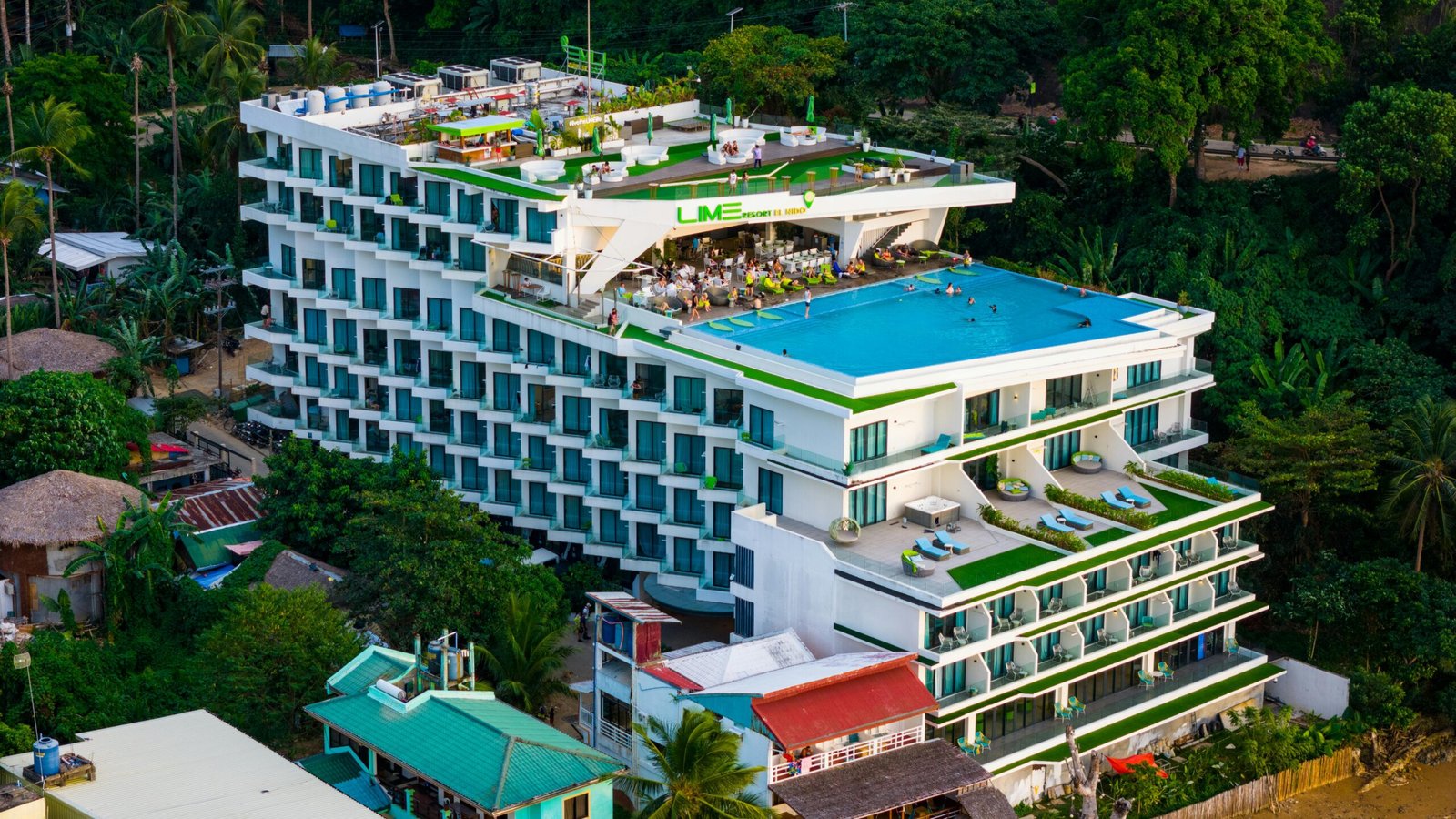 Luxurious rooftop pool at a modern hotel in El Nido, surrounded by lush greenery.