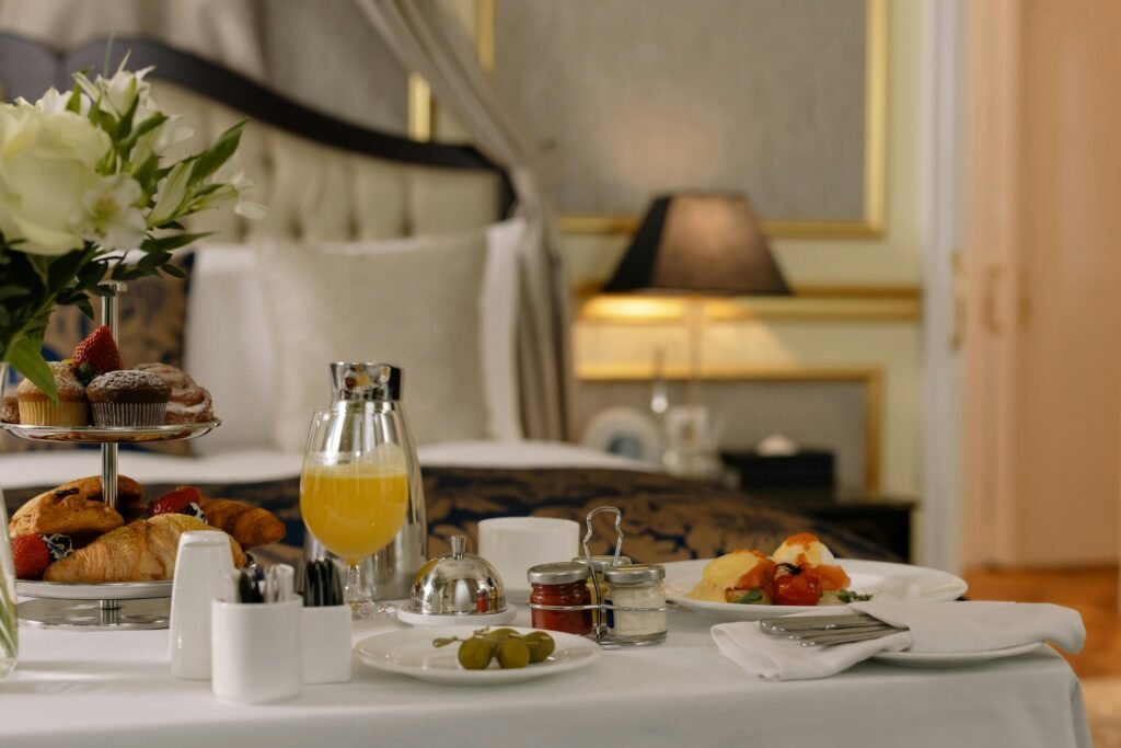 Elegant hotel room breakfast featuring pastries, orange juice, and a stylish table setting.