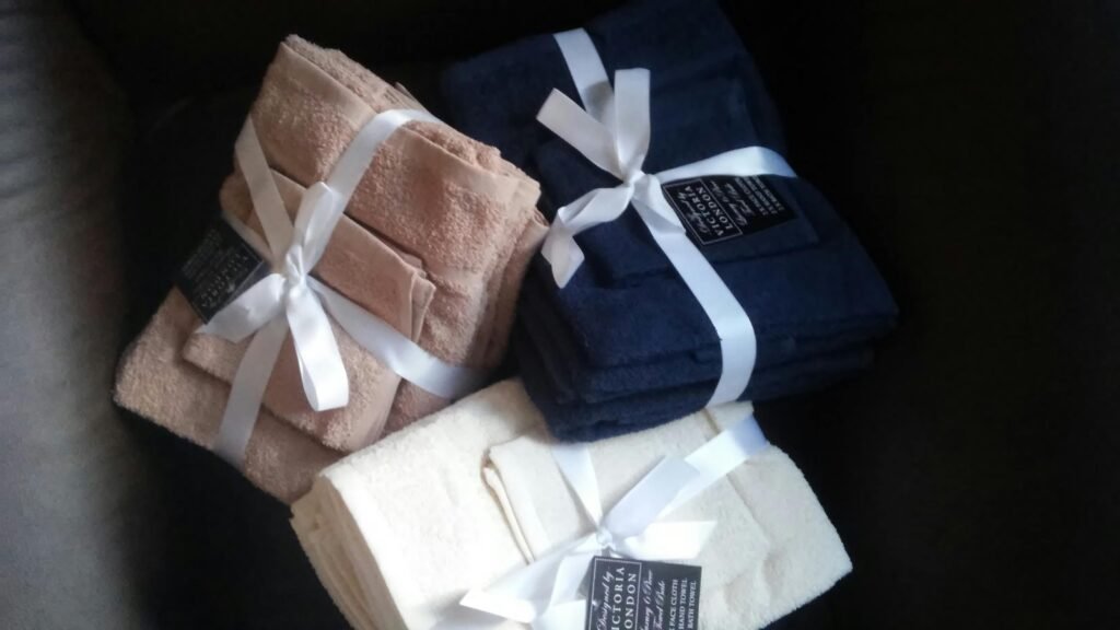 Three bundled sets of bath towels tied with ribbons, showcasing luxury and style.